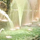 黄色くライトアップされた噴水の写真